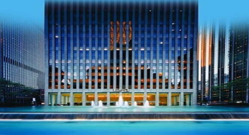 a building with glass walls and a fountain in front