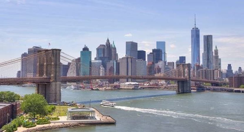 The Brooklyn Bridge over a river with New York City in the background