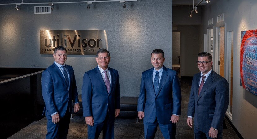 The Angerames in suits standing in the utiliVisor NY operations office