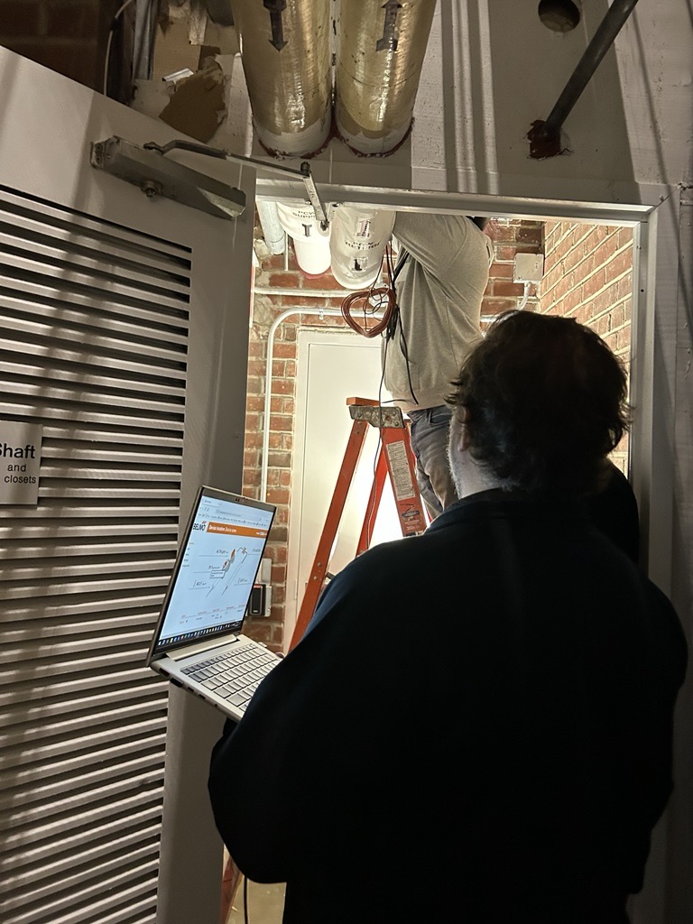 The fabulous Belimo quality team in action. Pictured are Jeff Upright (on ladder), Michael Jackson (holding laptop), and Brian Parks (black sweatshirt), making sure the fix was fixing. Source: Ed Harvey